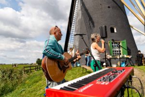 Muzikanten spelen bij een molen langs de route