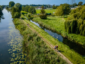 Luchtfoto van een wandelpad langs een sloot in de polder