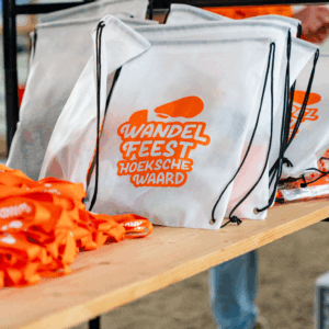 Rij goodiebags met het Wandel Feest-logo