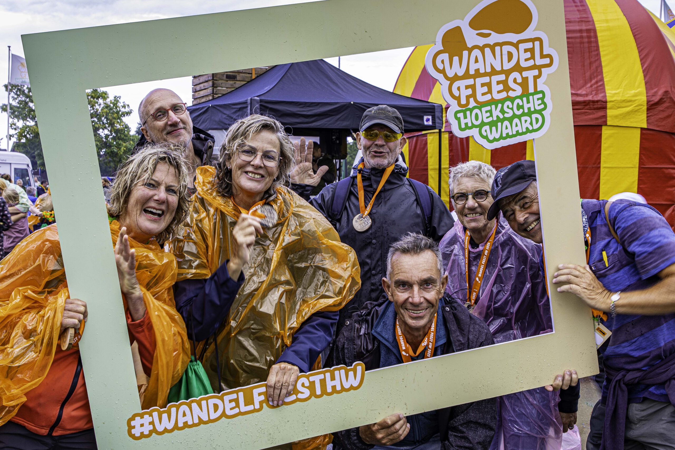 deelnemers bij wandel feest Hoeksche Waard met poncho's aan maar wel blij