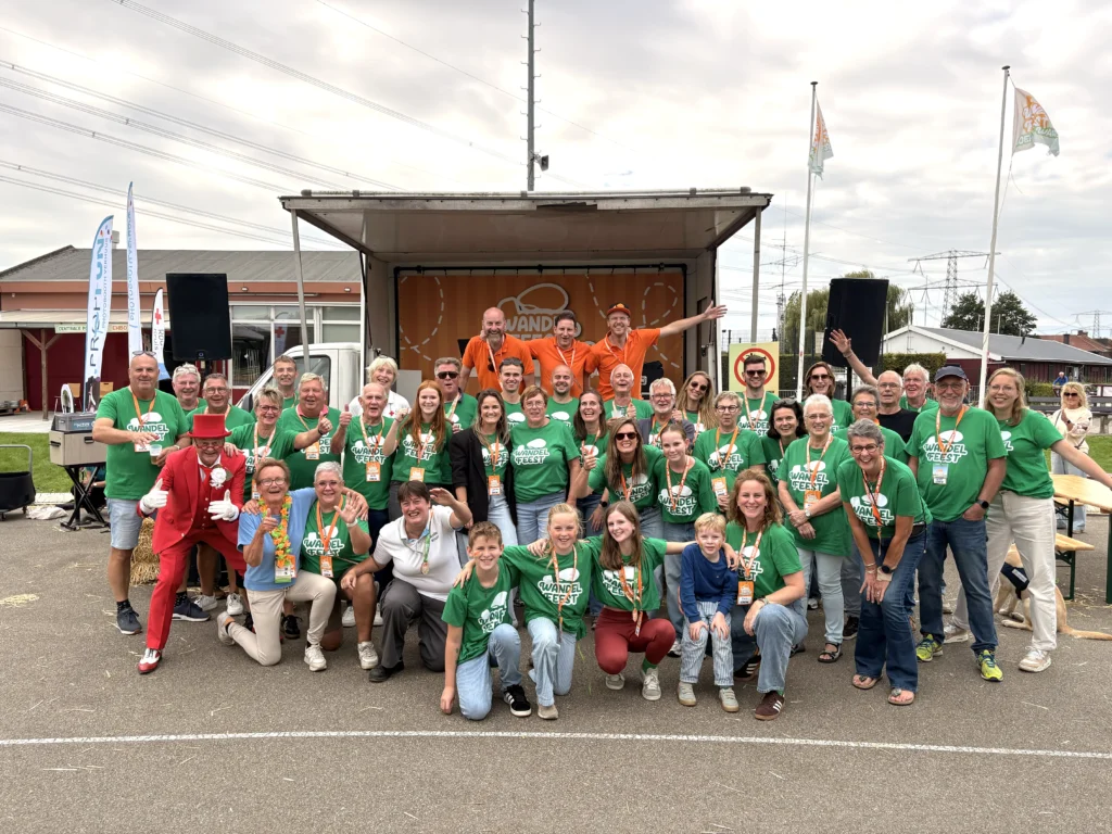 Het team van vrijwilligers in groene shirts bij het podium op de Kees Verkerkbaan